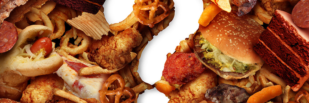 Fried and processed foods—burger, fried chicken, chips, pretzel, pizza, cake—on white background illustrating unhealthy fats