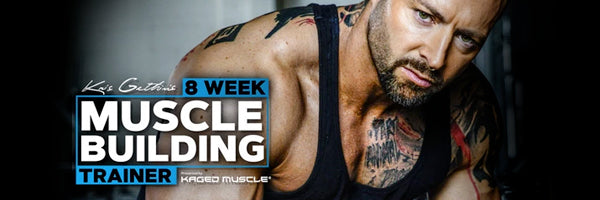 Tattooed muscular man poses in a dim gym beside a banner promoting an eight-week muscle-building trainer