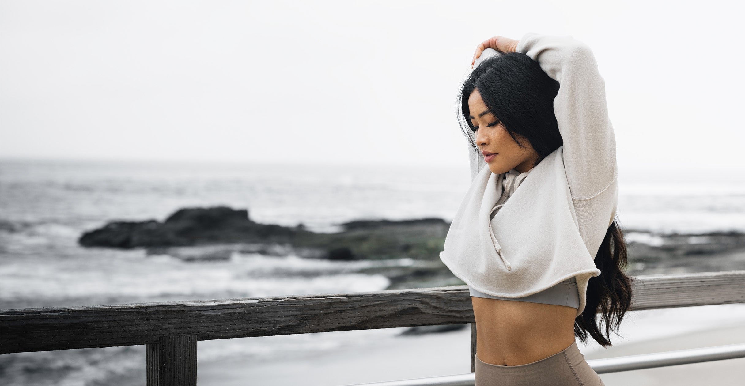 Female Kaged athlete stretching by the beach